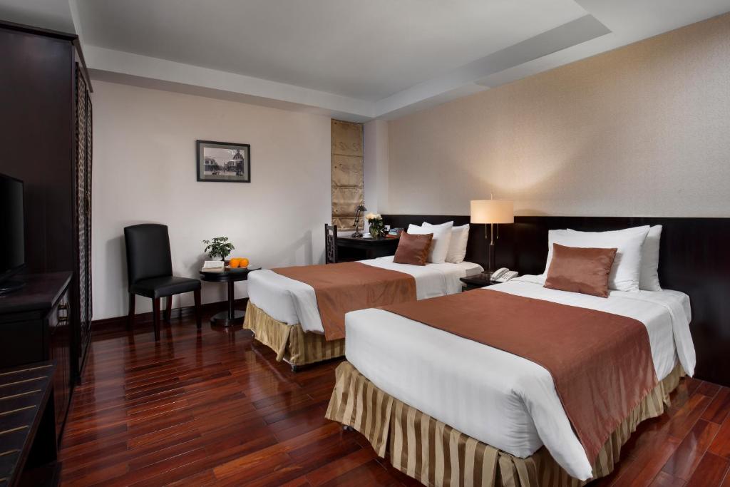 um quarto de hotel com duas camas e uma televisão de ecrã plano em TK123 Hanoi Hotel em Hanói