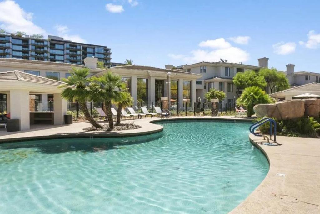 einem großen Pool mit Palmen und einem Gebäude in der Unterkunft The Nines Scottsdale in Scottsdale