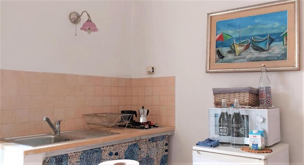 a kitchen with a sink and a microwave at Bed & Breakfast Porta d'Oriente in Brindisi