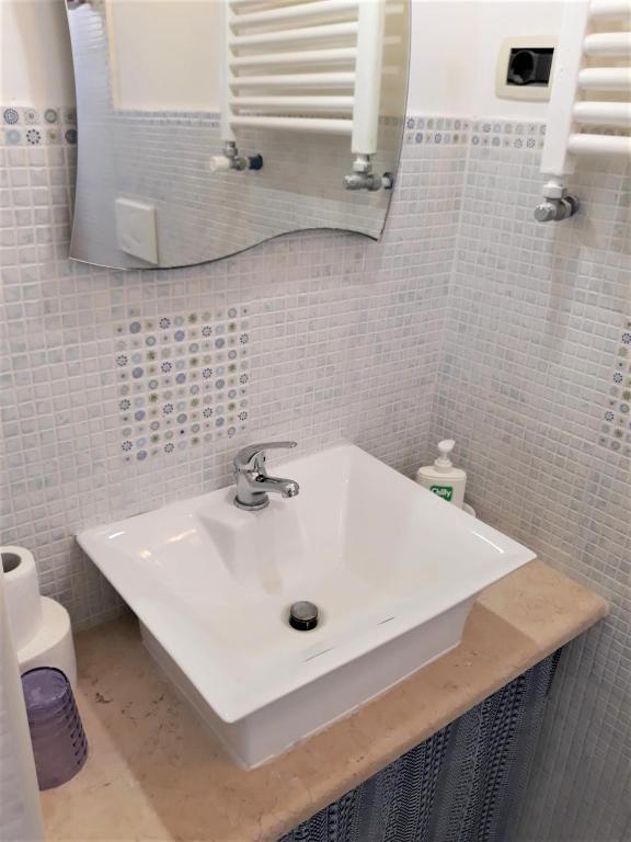 a bathroom with a white sink and a mirror at Bed & Breakfast Porta d'Oriente in Brindisi