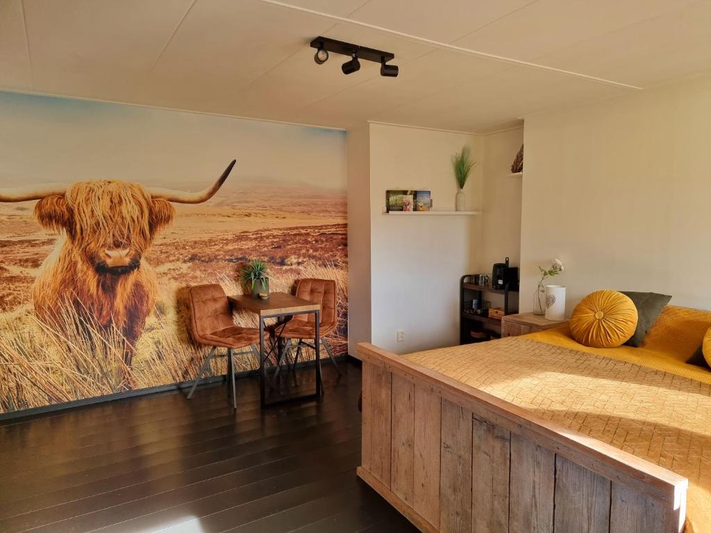 un dormitorio con una gran pintura de un toro en la pared en De Schotse Hooglander, en Smilde