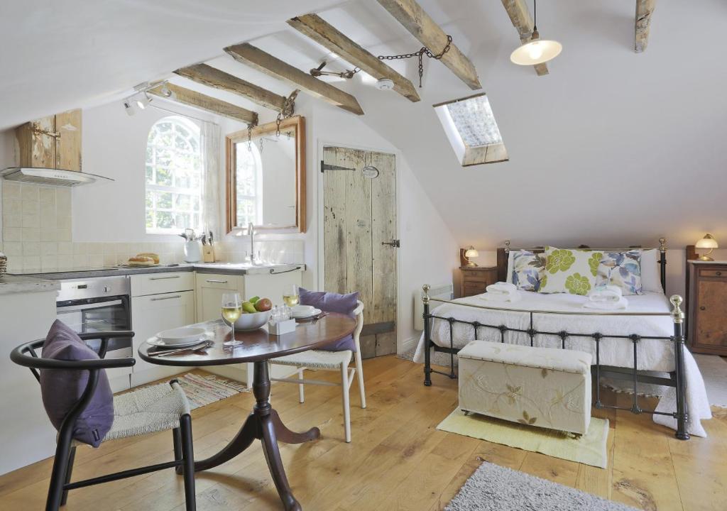 a kitchen and a bedroom with a bed and a table at The Carters Loft in Badingham