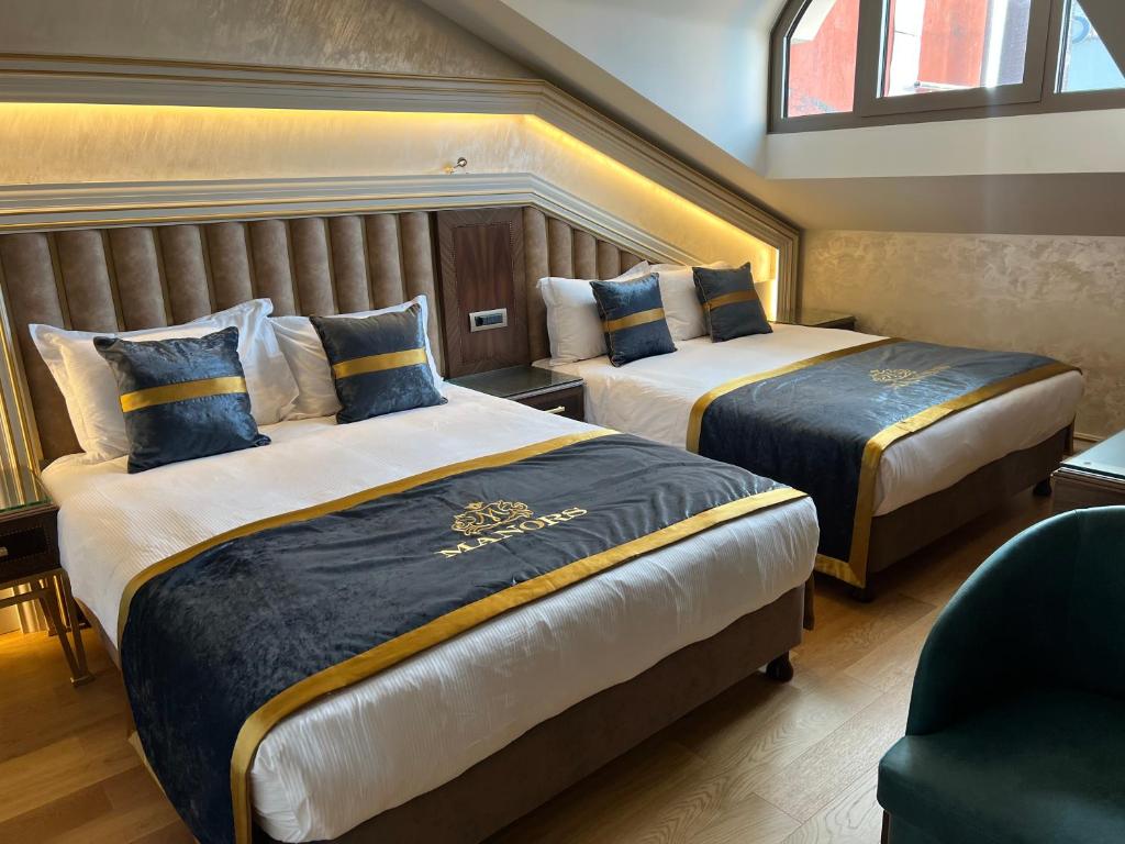 A bed or beds in a room at MANORS HOTEL
