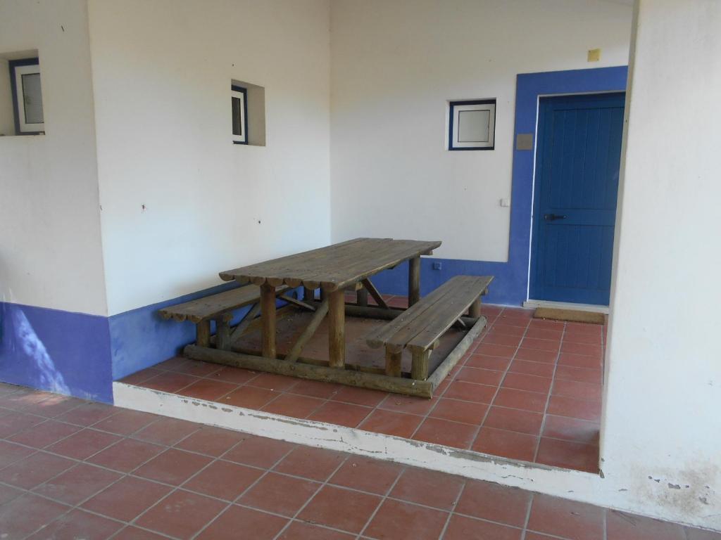 una mesa de picnic de madera en una habitación con puerta azul en Casa de Campo 1, en Lavre