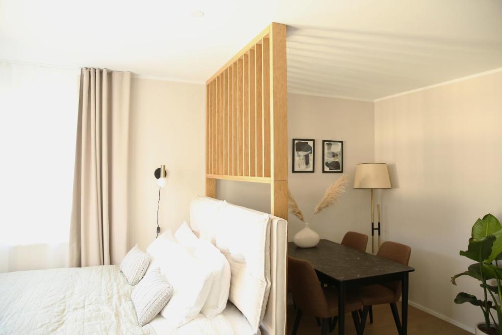 1 dormitorio con cama, escritorio y mesa en Lamira - Serviced Apartments en Zúrich