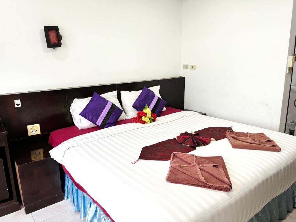 a bedroom with a large bed with purple and purple pillows at Lamai Apartment in Patong Beach