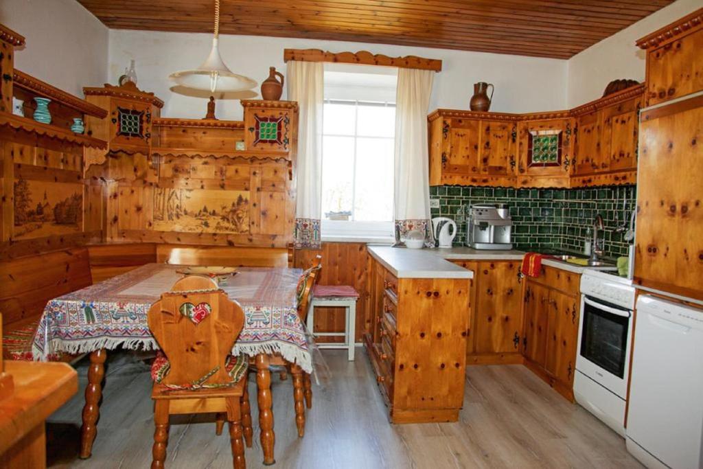 una cocina con armarios de madera y una mesa con sillas. en Ferienwohnung Gundacker en Dobersberg