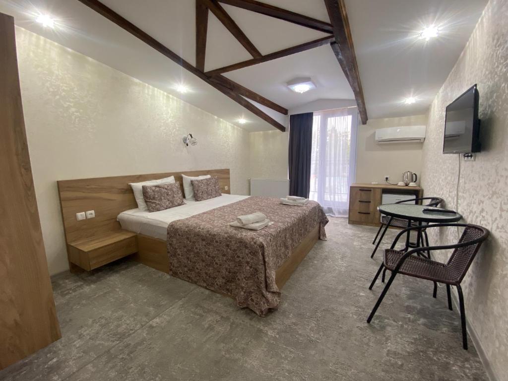 a bedroom with a bed and a table and a television at Hotel Traveler in Sighnaghi