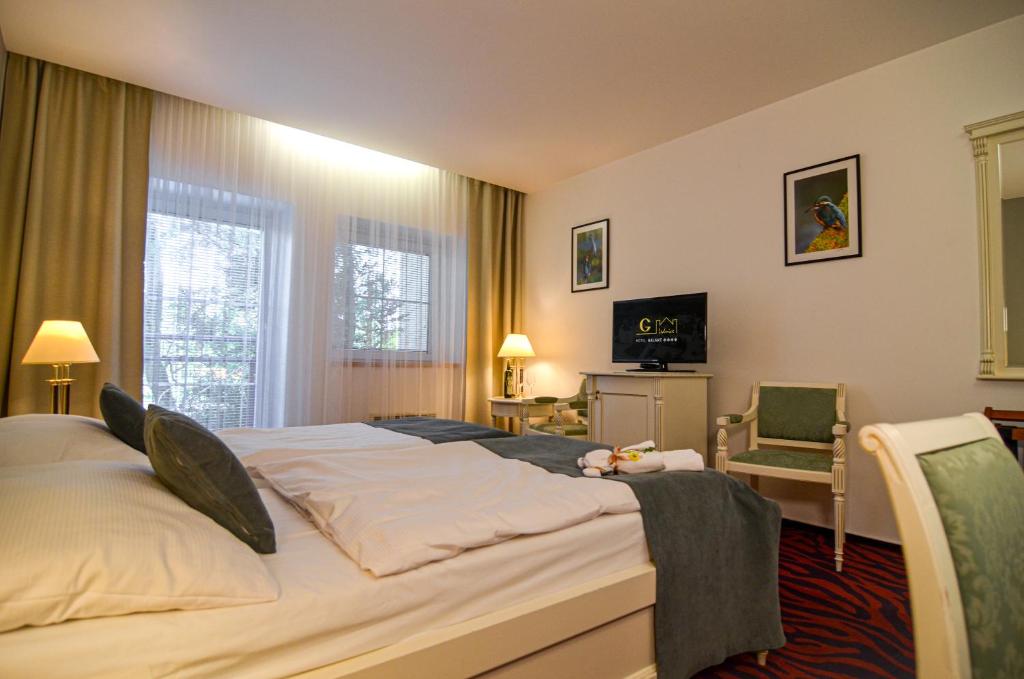 a bedroom with a large bed and a television at Hotel Galant Lednice in Lednice