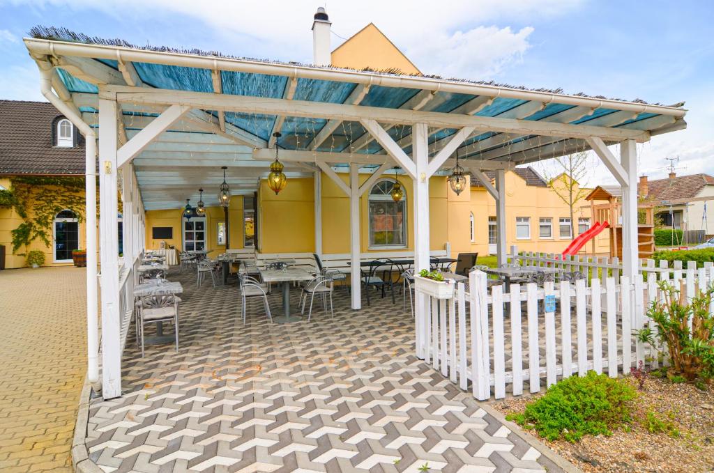 a wooden pergola with tables and chairs on a patio at Hotel Galant Lednice in Lednice