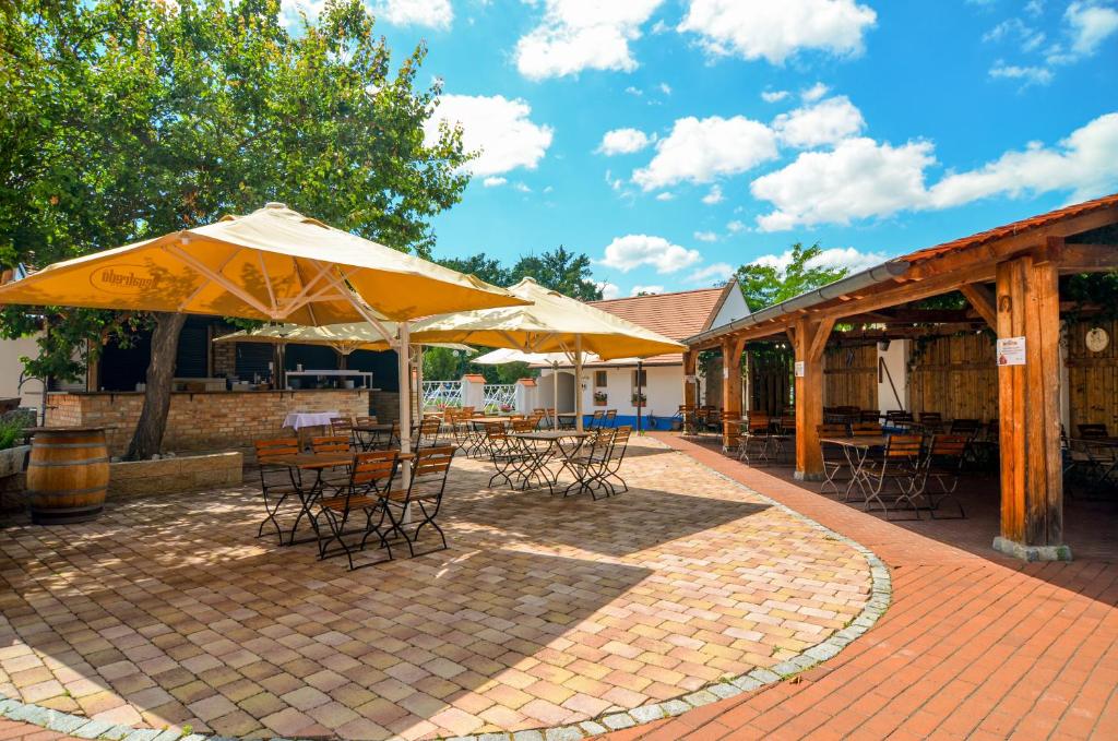 a patio with tables and chairs and umbrellas at Hotel Galant Lednice in Lednice