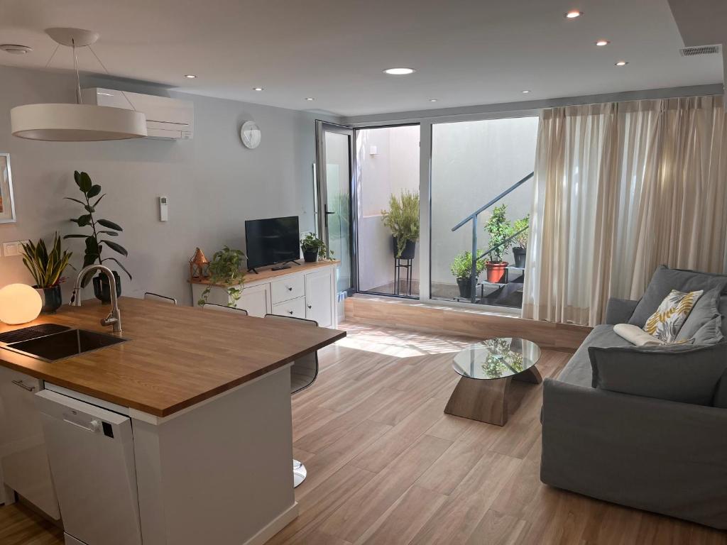 eine Küche und ein Wohnzimmer mit einem Sofa und einem Tisch in der Unterkunft Modern Apartment by the Airport IFEMA - 1 Bedroom in Madrid