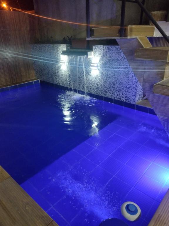 a swimming pool with blue tiles on the floor at Casa de praia Rocha Alves em Porto de Galinhas in Porto De Galinhas