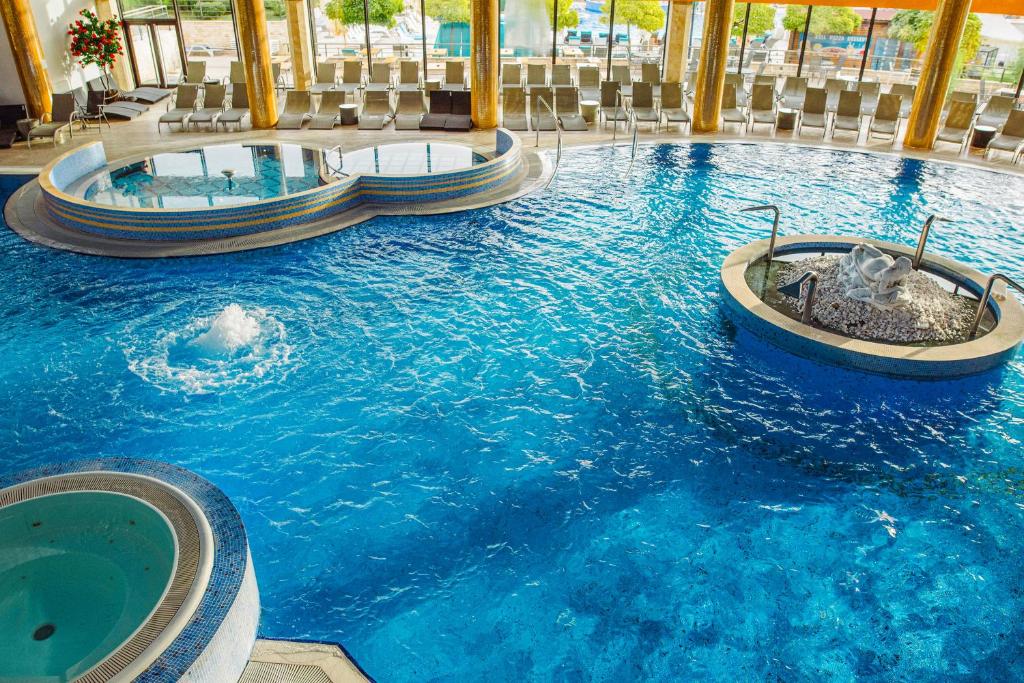 a large swimming pool with two hot tubs in a resort at A Hoteli - Hotel Izvor in Arandelovac