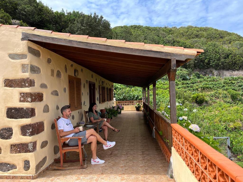 two people sitting on a porch of a house at Casa Rural Quilla in Agulo