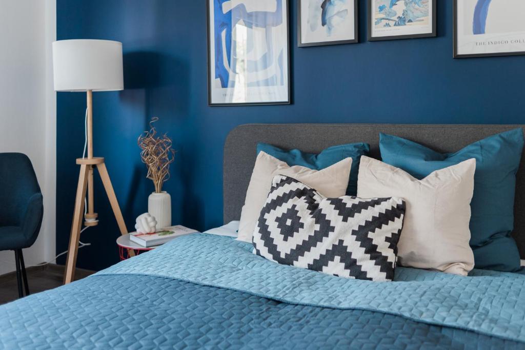 una camera da letto con pareti blu e un letto con cuscini di Pöttyös Ponty Elegance Boutique Vendégház a Kisköre