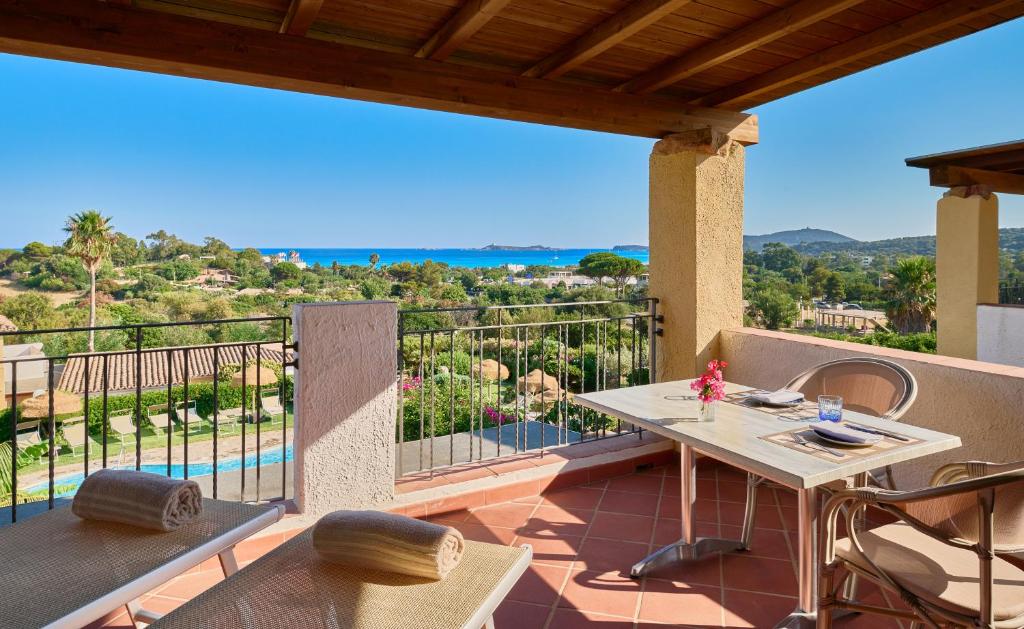 eine Terrasse mit einem Tisch und Stühlen auf dem Balkon in der Unterkunft Residence Le Bouganville in Villasimius