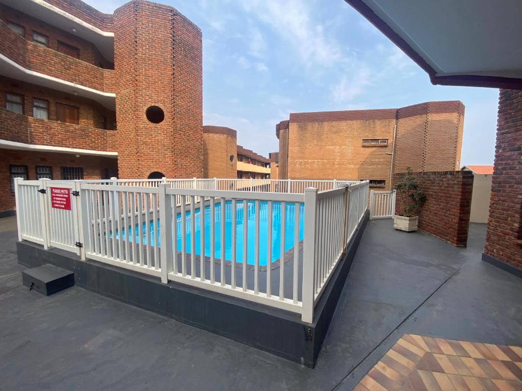 a white fence around a swimming pool in a building at See Uitsig 2 in Uvongo Beach