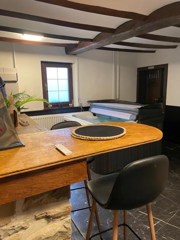Cette chambre comprend une table en bois et une chaise. dans l'établissement Casa Wellness Floreffe jacuzzi, à Floreffe