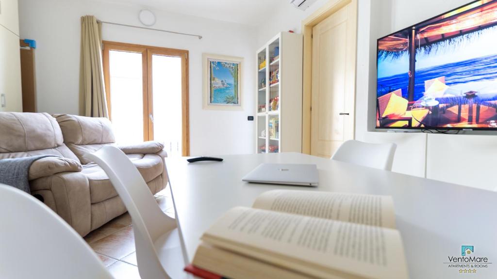 een woonkamer met een bank en een tafel met een laptop bij Vento Mare Apartments in Palau