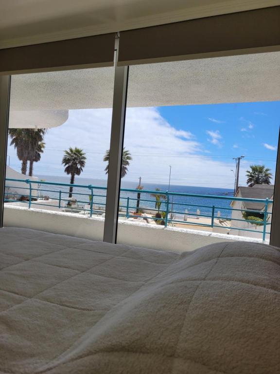 1 dormitorio con vistas al océano desde la playa en Playa Paraíso Resort, en Concón