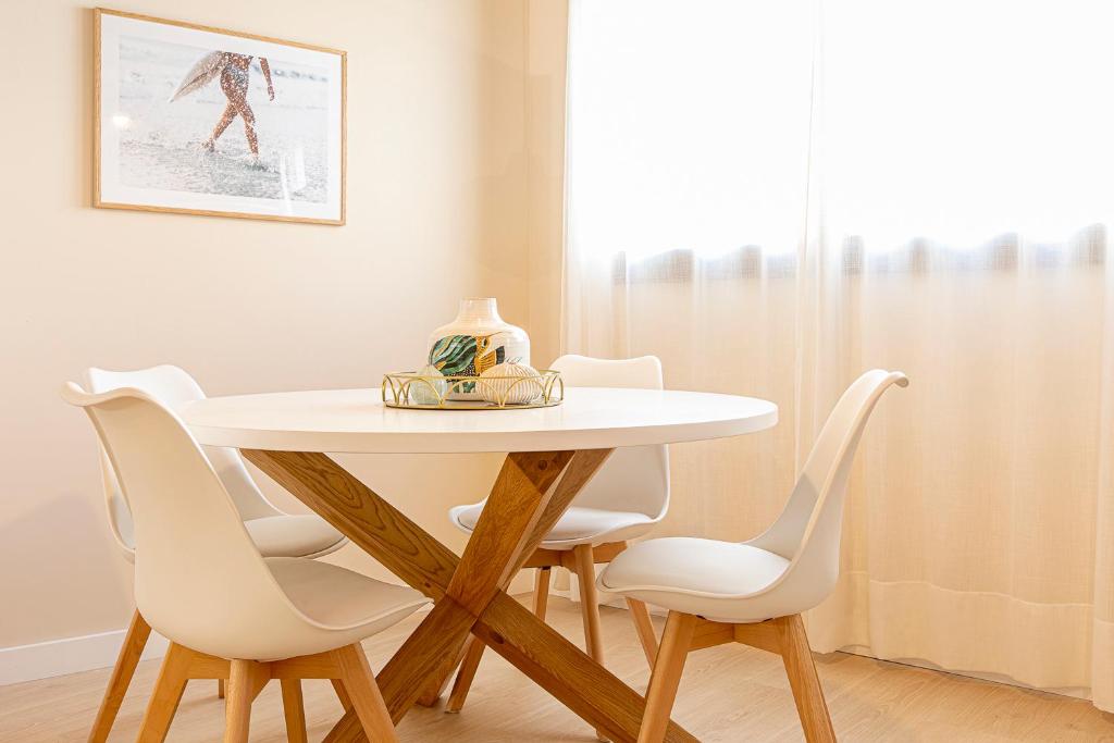 a dining room table with white chairs around it at Barcelona Touch Apartments in Hospitalet de Llobregat