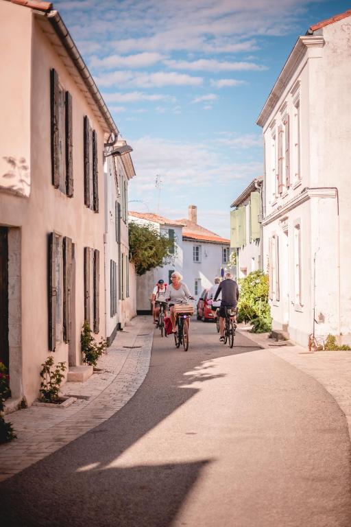 a group of people riding bikes down a street at Le Phare in Les Portes