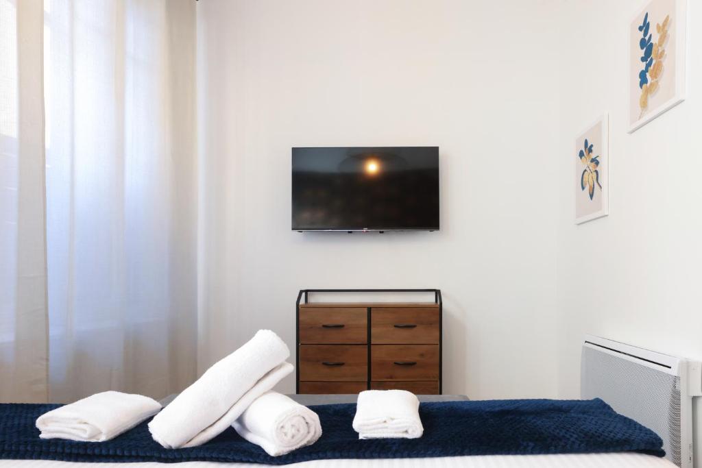 sypialnia z telewizorem i łóżkiem z ręcznikami w obiekcie N1 Des Études Cosy Duplex Netflix Balcon ConciergerieDameCarcas w Carcassonne