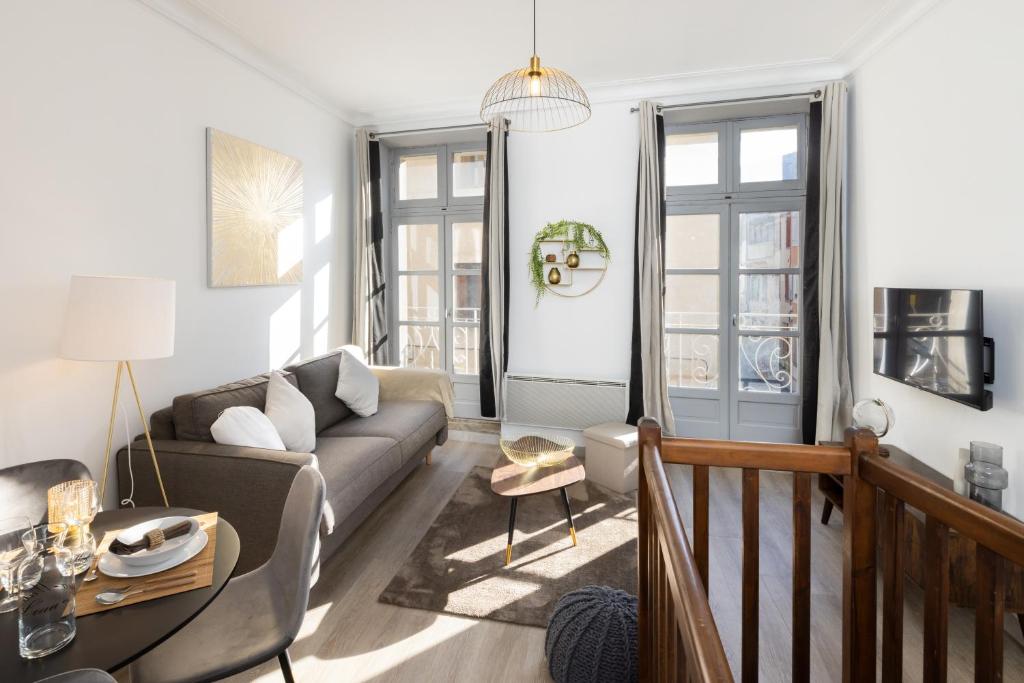 salon z kanapą i stołem w obiekcie N1 Des Études Cosy Duplex Netflix Balcon ConciergerieDameCarcas w Carcassonne
