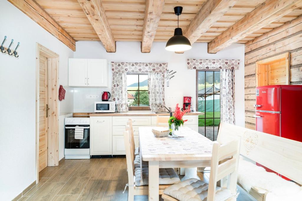 een keuken met een tafel en een rode koelkast bij Drevenice Liptov - apartments under the mountains in Lazisko
