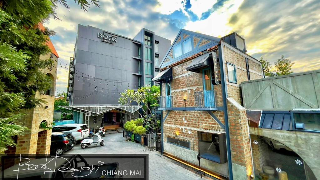 ceglany budynek z samochodem zaparkowanym przed nim w obiekcie BOOK Design HOTEL -SHA Extra Plus w mieście Chiang Mai