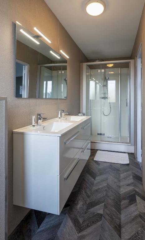 a bathroom with two sinks and a shower at Hôtel du Musée in Granville