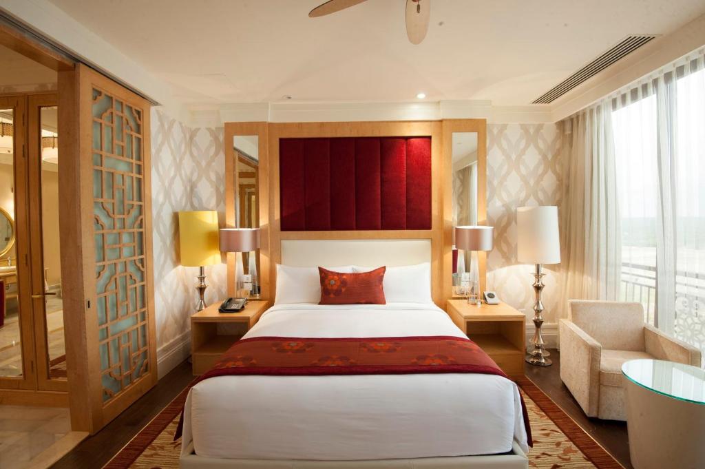 a bedroom with a large bed and a large window at InterContinental Grand Ho Tram in Ho Tram