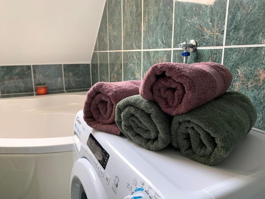 a pile of towels sitting on top of a sink in a bathroom at Hangulatos társasházi apartman Pécs belvárosában in Pécs