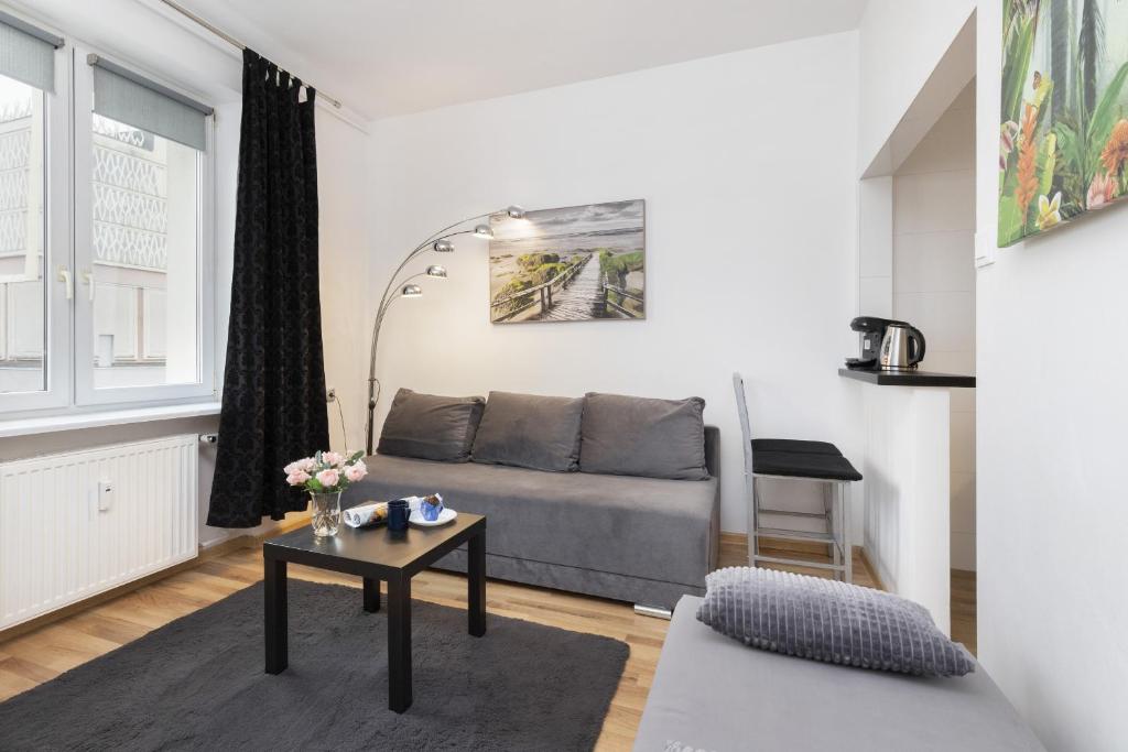 格地尼亞的住宿－Batorego Studio Apartment Downtown Gdynia by Renters，客厅配有沙发和桌子