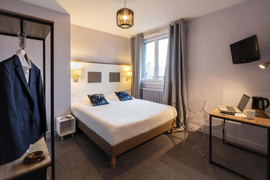 a hotel room with a bed and a mirror at Hôtel du Musée in Granville