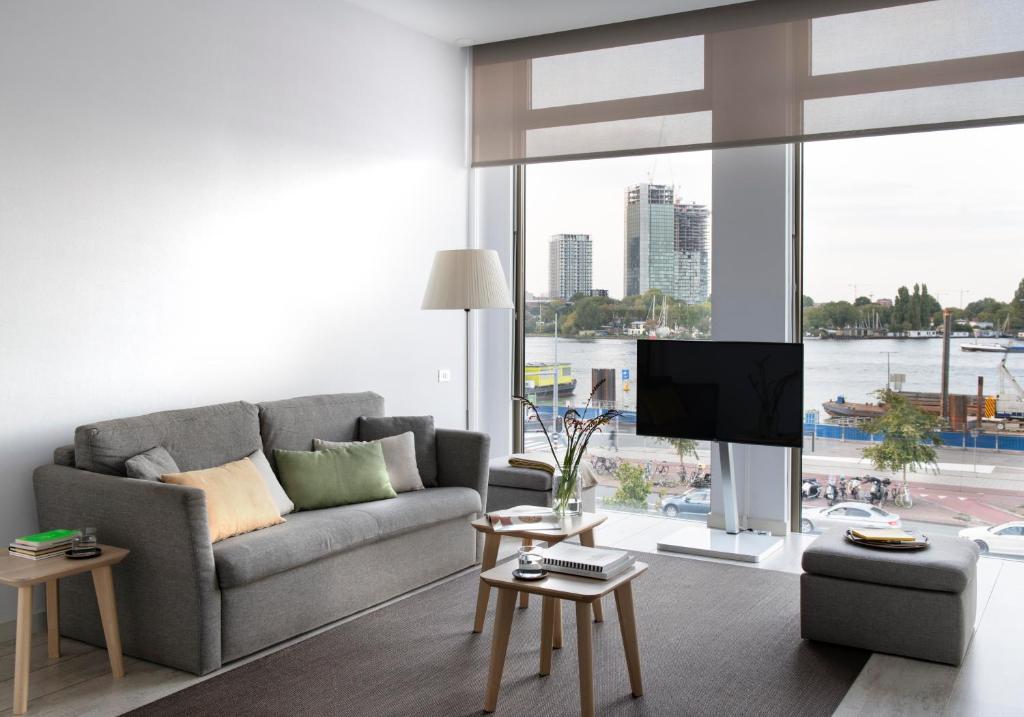 a living room with a couch and a flat screen tv at Eric Vökel Boutique Apartments - Amsterdam Suites in Amsterdam