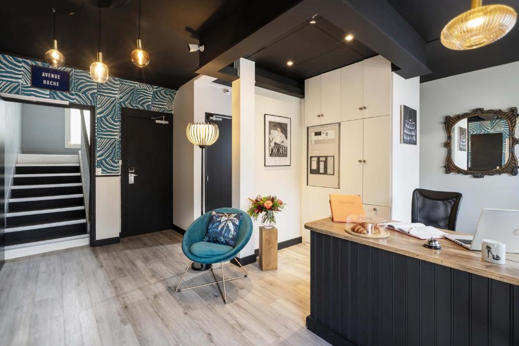 een kamer met een bureau en een blauwe stoel bij Hôtel du Musée in Granville