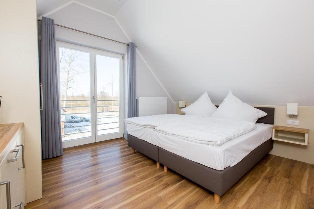 a bedroom with a bed and a large window at Apartment am Yachthafen Whg 8 optional Bootsplatz in Plau am See