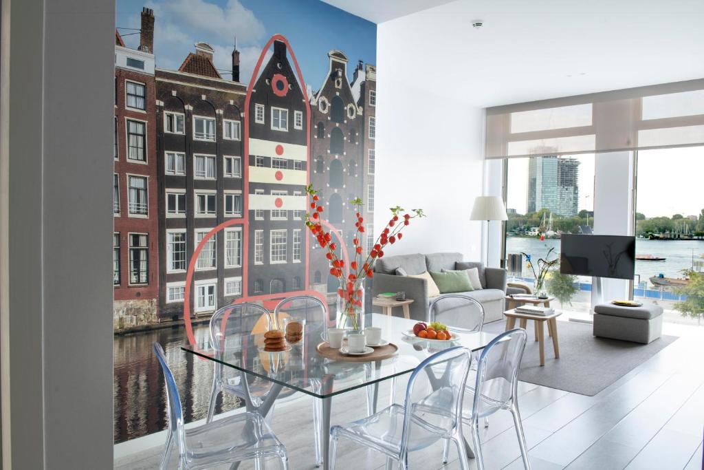 a living room with a table and chairs and a building mural at Eric Vökel Boutique Apartments - Amsterdam Suites in Amsterdam
