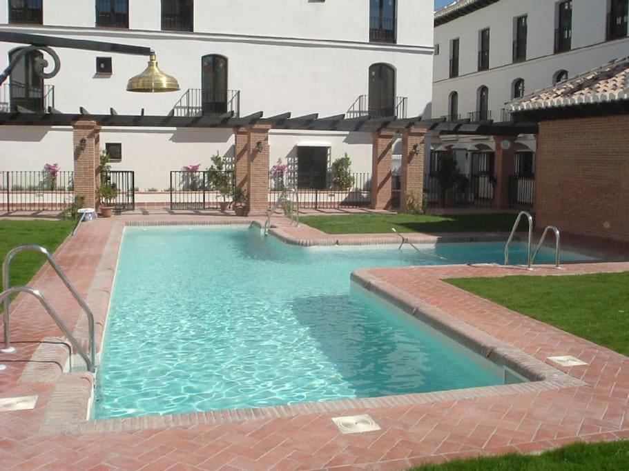 una piscina en un patio con un edificio en Boutique Style Apartment in Velez de Benaudalla - near Salobrena, en Vélez de Benaudalla