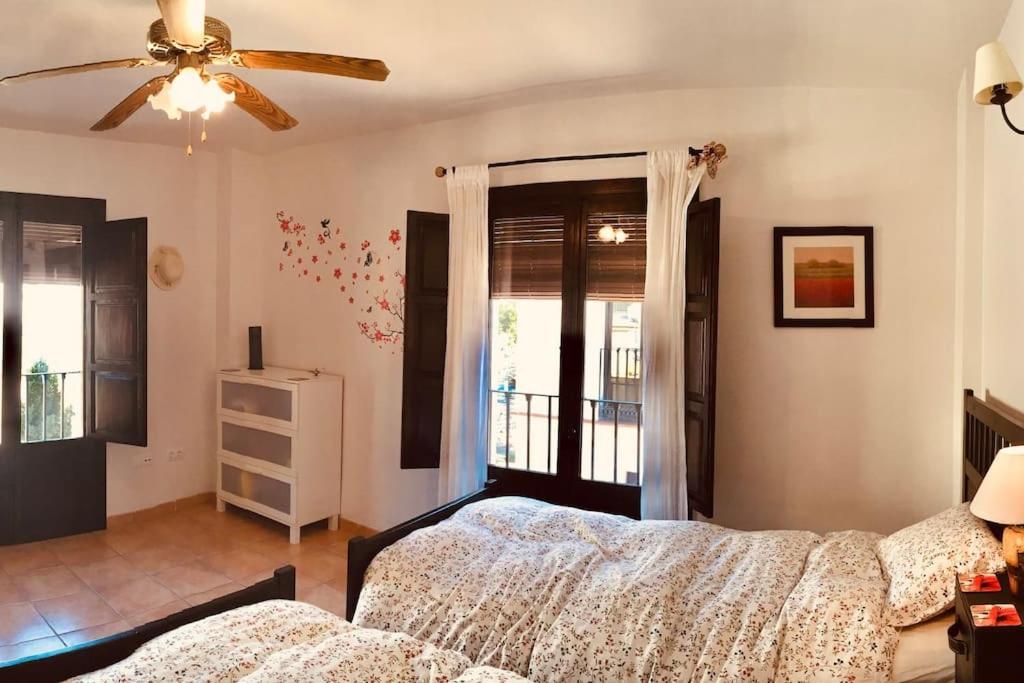 a bedroom with a bed and a ceiling fan at Boutique Style Apartment in Velez de Benaudalla - near Salobrena in Vélez de Benaudalla