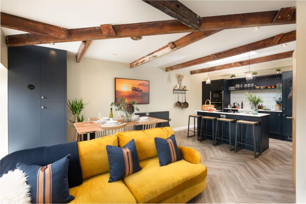 Sullivans Loft في نيلين: غرفة معيشة مع أريكة صفراء ومطبخ
