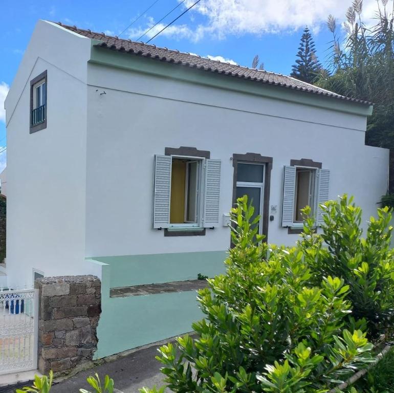 une maison blanche avec des arbres devant elle dans l'établissement Casa Pyrrhula Murina - Private Jacuzzi, à Nordeste