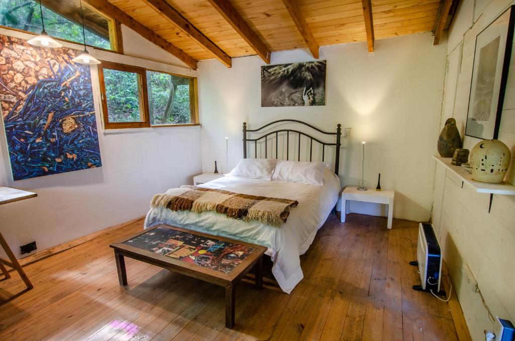 um quarto com uma cama e uma mesa em la casa del sol em San Carlos de Bariloche