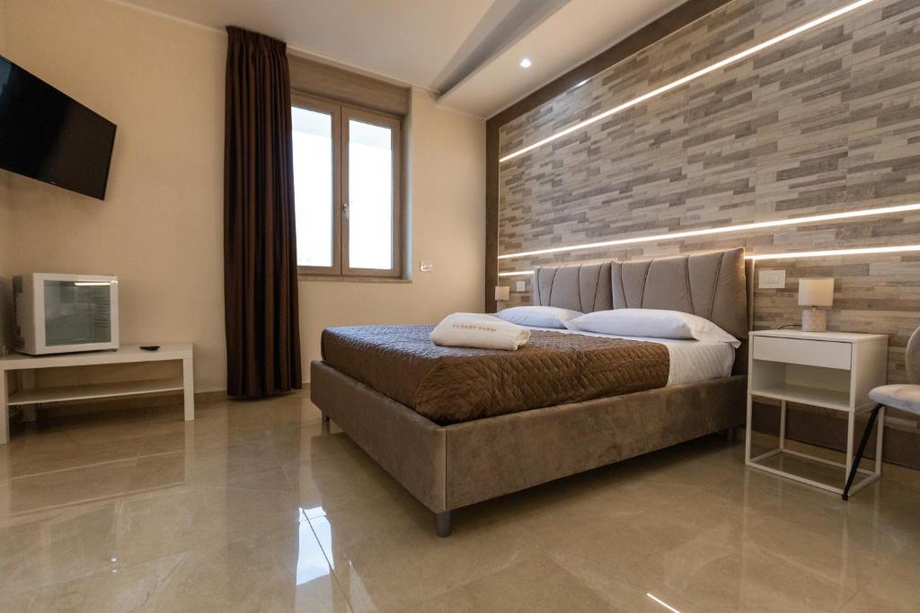 ein Schlafzimmer mit einem großen Bett und einem TV in der Unterkunft Agri-Resort Luxury Farm in Marigliano
