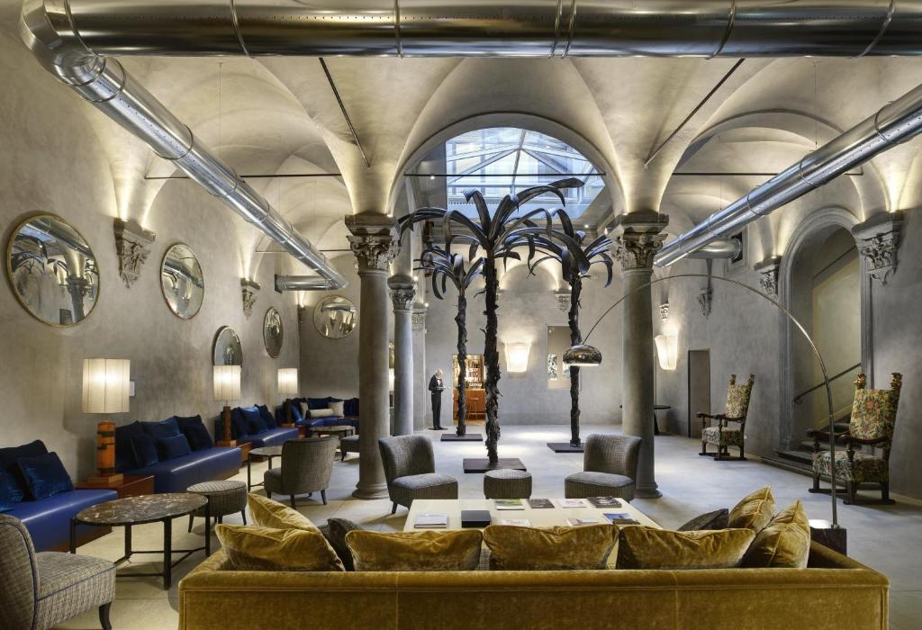 a lobby with a couch and chairs in a building at Hotel Garibaldi Blu - WTB Hotels in Florence