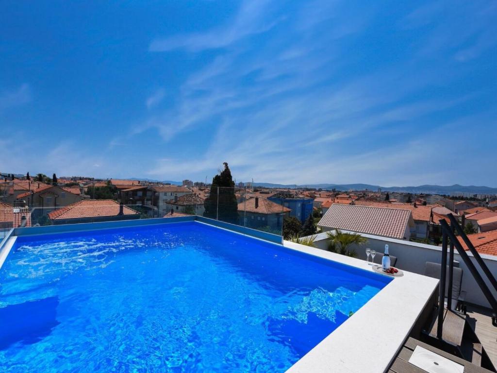 a large blue swimming pool on top of a building at Rooftop heated pool Villa Jelena in Zadar