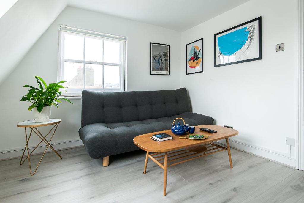 uma sala de estar com um sofá e uma mesa em Newly Renovated Central One-Bedroom, 99 Steps to the Sea em Brighton & Hove