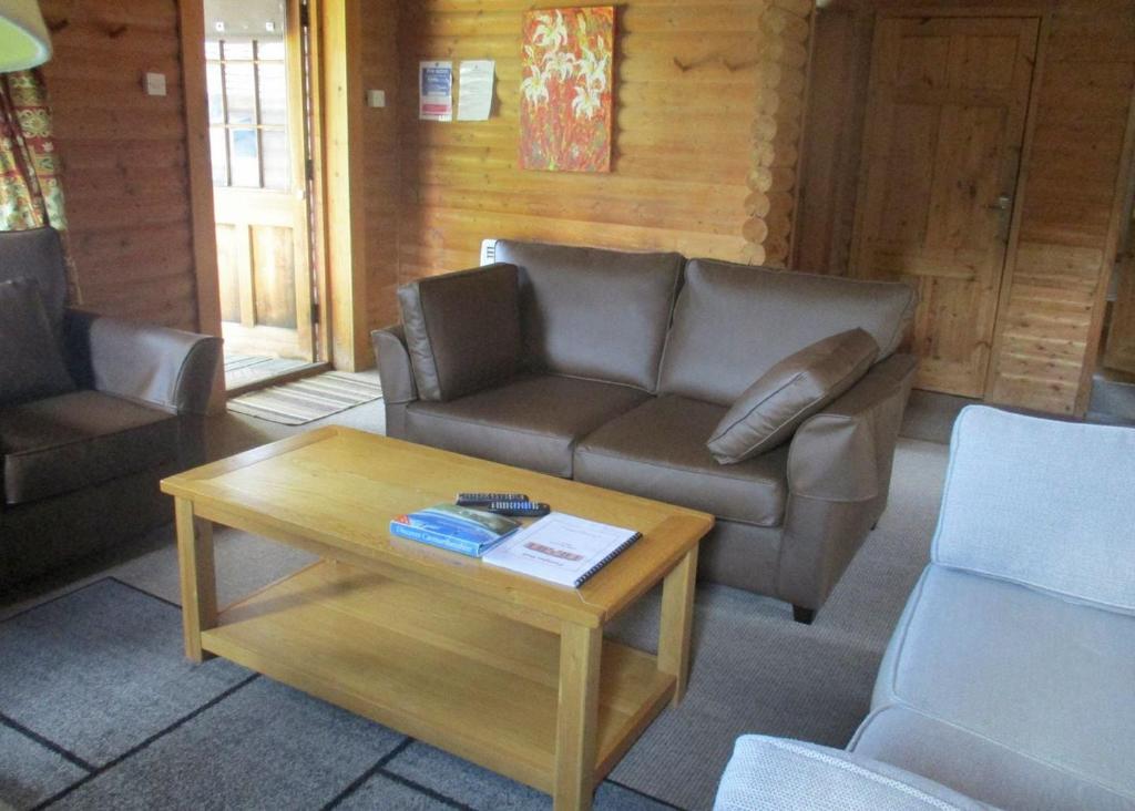 a living room with a couch and a coffee table at Pantglas Hall Lodges in Llanfynydd